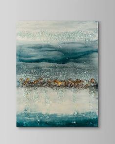 an abstract painting with blue, white and gold colors on the canvas in front of a gray wall