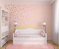 a pink and gold girls'room with polka dot decals on the wall, white daybed in foreground