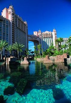 the resort is surrounded by palm trees and clear blue water in front of an overhanged building