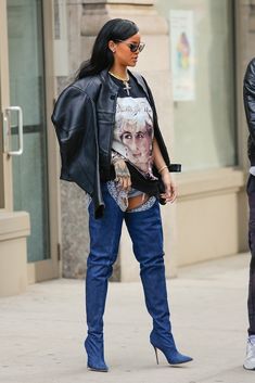 a woman in high heel boots is walking down the street