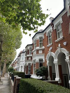 a row of red brick townhouses with white trim and arched doorways on either side