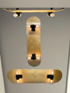 two skateboards hanging from the ceiling with lights on them and one above it's head