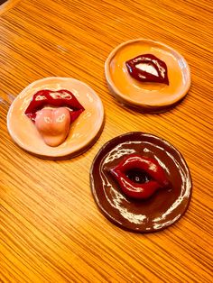 three desserts with chocolate and candy on them sitting on top of a wooden table