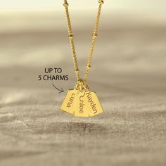 two gold necklaces with the words, up to 5 charms on them and an arrow