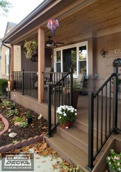 the front porch is decorated with flowers and plants