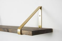 a wooden shelf with metal brackets on it