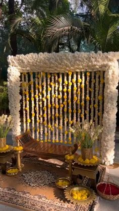 an outdoor area with flowers and decorations on the ground, including a bench made out of wood