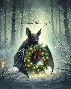 a bat is holding a wreath with lights on it in the middle of a snowy forest