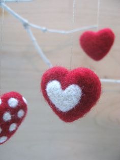 three red and white hearts hanging from strings