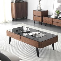 a modern coffee table with glass top and wooden legs in a living room setting on carpeted flooring