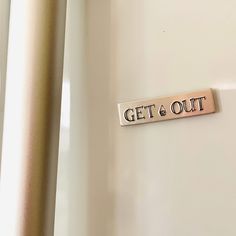 a sign that says get & out hanging on the side of a wall next to a door