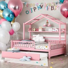 a pink bed frame with balloons and confetti