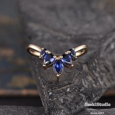 a gold ring with three blue stones on it