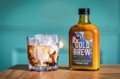 a bottle of cold brew next to a glass filled with ice