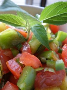 a salad with tomatoes, cucumbers and green leaves