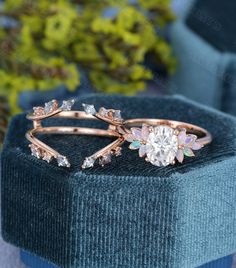 an engagement ring with a flower and leaves design on the side, sitting in a velvet box