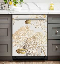 a white and gold floral design on the front of a dishwasher in a kitchen