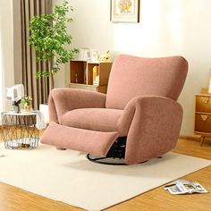 a living room with a pink chair and white rug on the wooden floor next to a potted plant