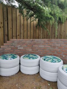 four white frisbees sitting in front of a brick wall