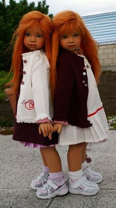 two dolls are standing next to each other