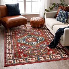 a living room with a couch, chair and rug on the floor in front of a window