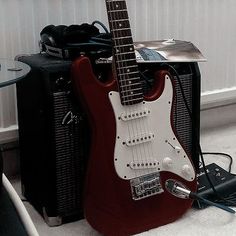 an electric guitar sitting on top of a table next to two amps and a speaker