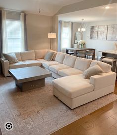 a living room filled with furniture and a large white couch in front of a window