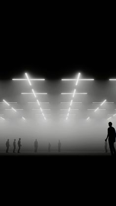 silhouettes of people standing in front of an illuminated room