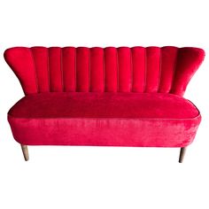 a red couch sitting on top of a white floor