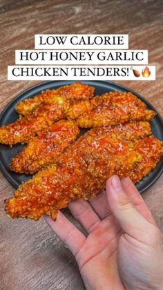 someone is holding up some chicken tenders on a plate with the words low calorie hot honey garlic chicken tenderies