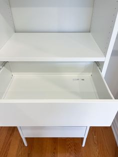 two white shelving units sitting on top of a hard wood floor