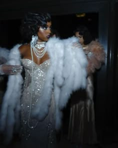 a woman dressed in white feathers and pearls