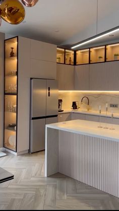 a modern kitchen with stainless steel appliances and marble counter tops, along with herring tile flooring