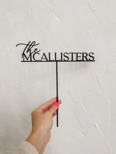 a person holding up a sign that says the mcalisters on it's side