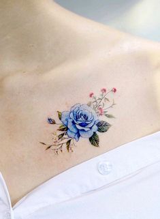 a woman with a blue rose tattoo on her chest