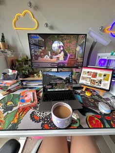 a laptop computer sitting on top of a desk next to a cup of coffee