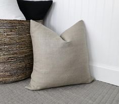 two pillows sitting next to each other on top of a bed with white walls behind them