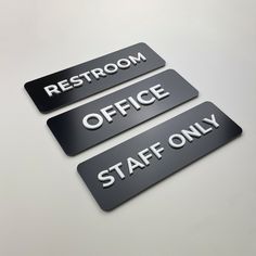 three black and white signs that say restroom, office, staff only on a table