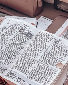 an open bible sitting on top of a table next to other books and purses