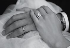 two people holding each other's hands with their wedding rings on top of them