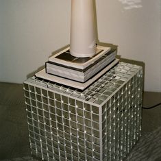 a white lamp sitting on top of a stack of books