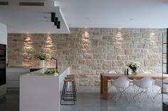 a kitchen and dining area with stone wall in the back drop off from the living room