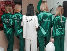 the bridesmaids are wearing green satin pajamas and matching robes with white balloons in front of them