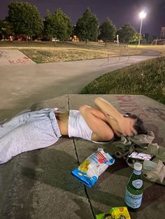 a person laying on the ground next to food and water bottles in front of them