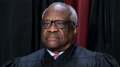 an older man wearing glasses and a judge's robe