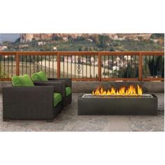 a fire pit sitting on top of a patio next to two couches and a table