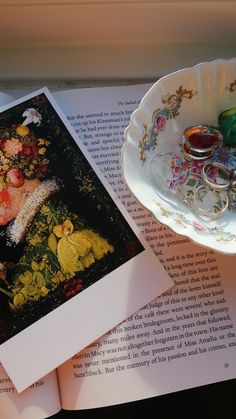 an open book with pictures on it next to a cup and saucer