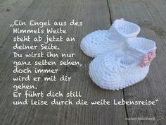 a pair of white slippers sitting on top of a wooden floor next to a poem written in german