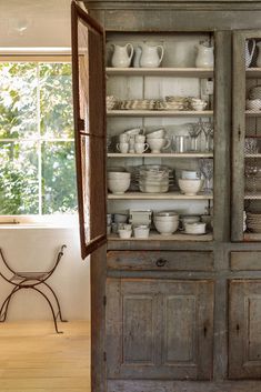 an old china cabinet is filled with dishes