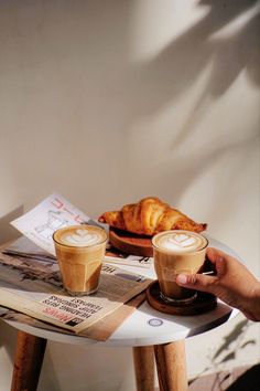 two cups of coffee sitting on top of a table